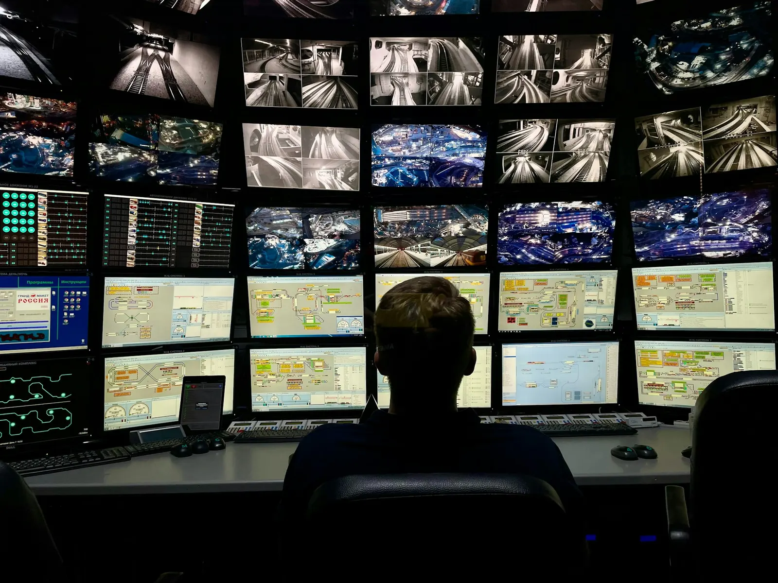A person seated in front of a wall of monitors in a darkened control room, the kind of setup a team uses to watch a story spread in real time