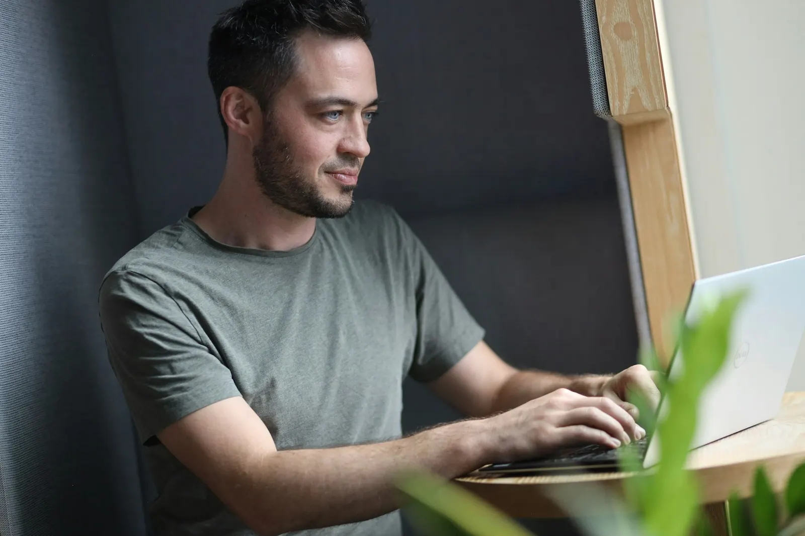 A founder working at a laptop by a window in natural light
