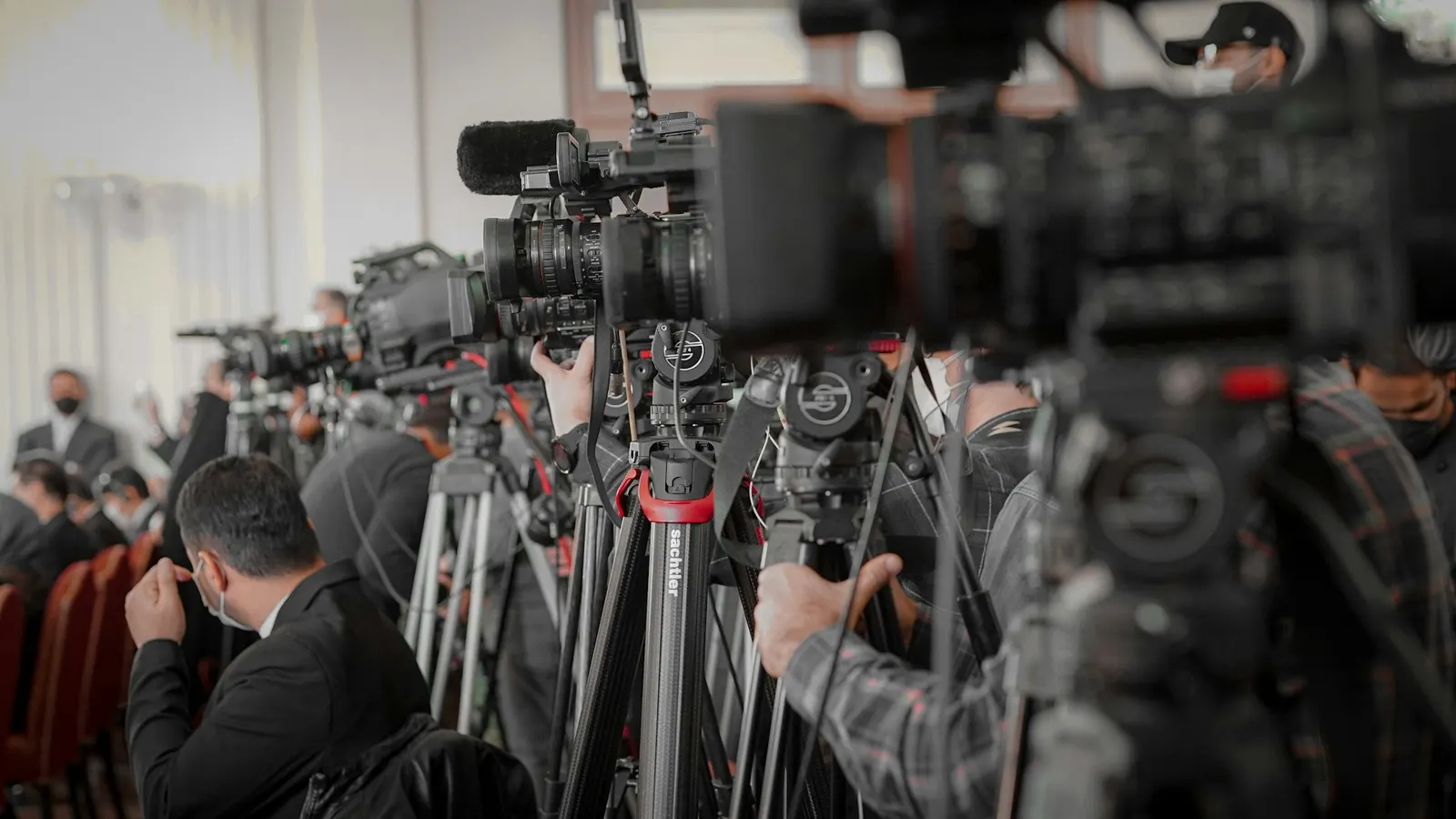 Camera operators and journalists lined up to cover a press event